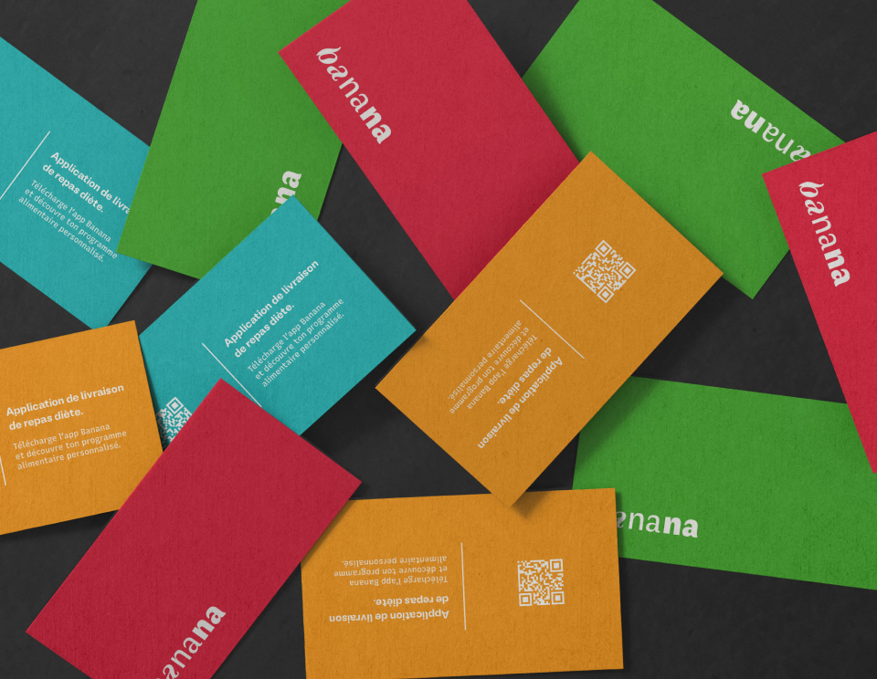 Mockup de cartes de visite multicolores pour Banana. Cluster dynamique décliné dans les quatre couleurs de l'identité visuelle (vert, rouge, bleu, orange) avec le logo vectoriel Banana Nutrition & Fitness. Design par Léo Simsolo.